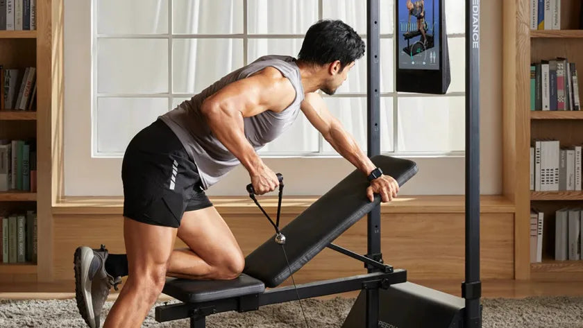 A man training on Gym Monster 3 at home in a bright, book-lined living room