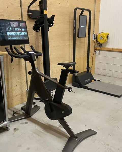 A Gym Monster in a garage room next to an exercise bike