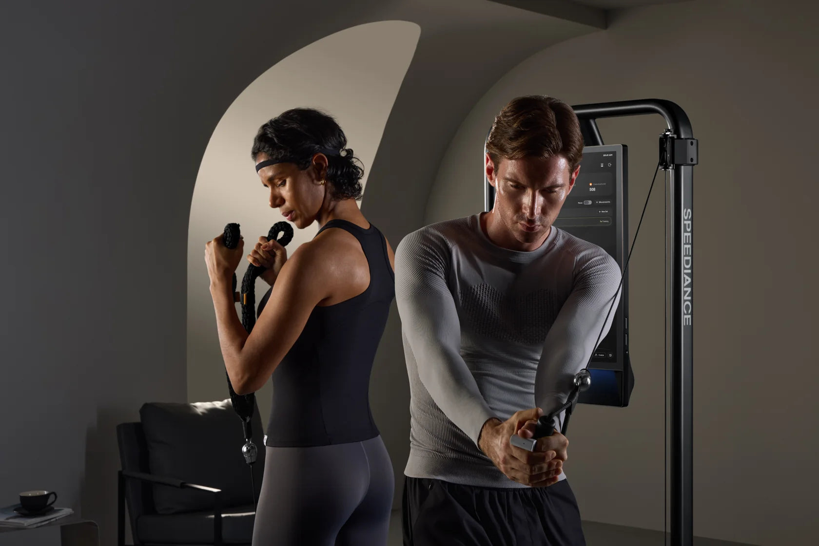 Two adults training side by side on Gym Monster 3 in a home setting