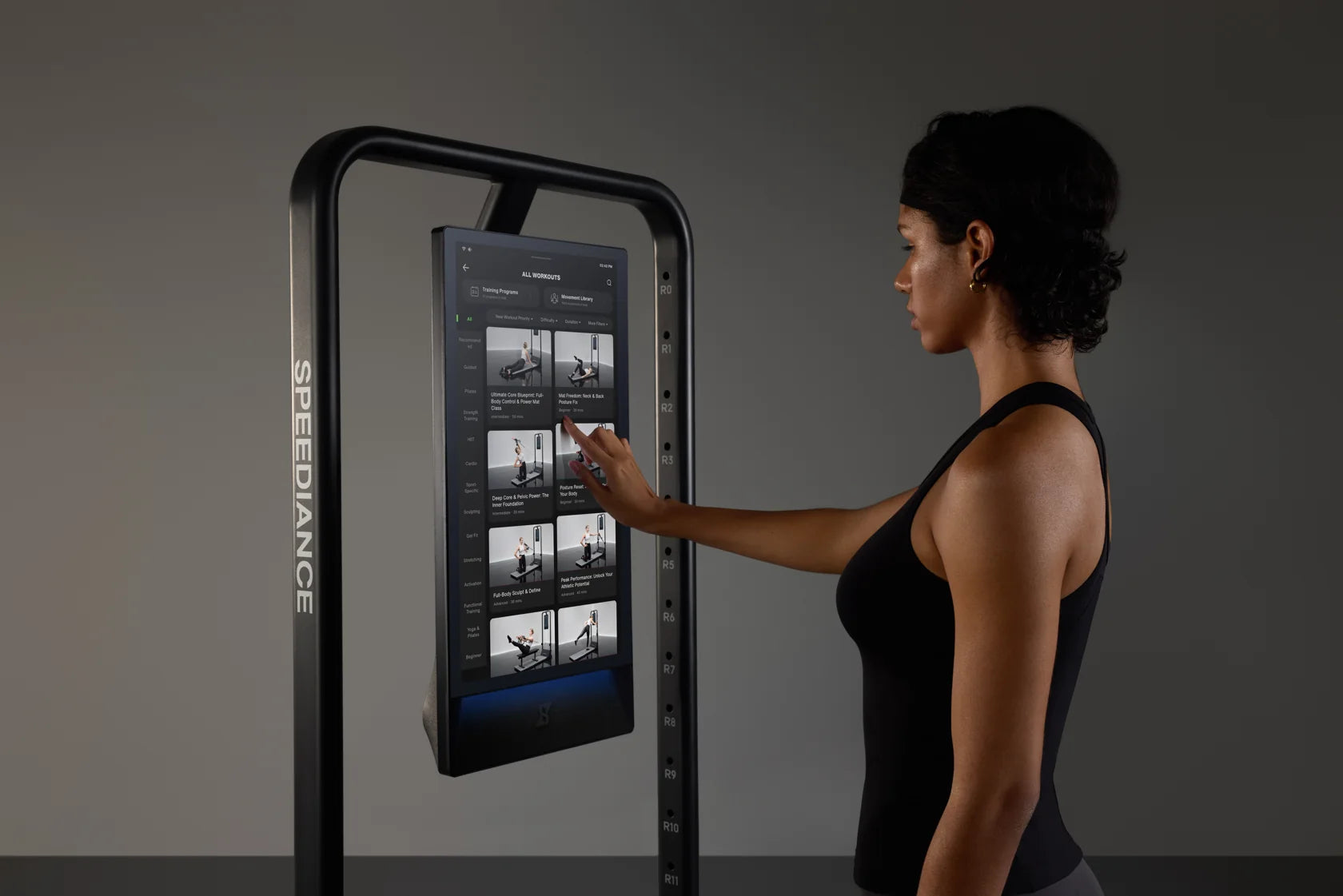 Une femme sélectionne un exercice sur l'écran tactile du Gym Monster 3